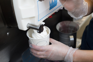 A Sno Top Ice Cream employee serves a cup of vanilla ice cream at the shop which has remained a local favorite in the area for 60 years. The shop, which is a 15-minute drive from Syracuse University, serves about 500 customers every day — many of whom are regulars who stop by more than once per week.