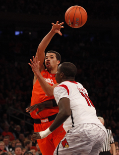 Michael Carter Williams passes the ball over Louisville's Gorgui Dieng (#10)