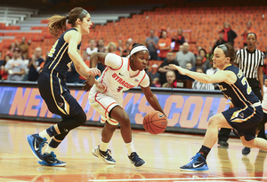 Alexis Peterson drives past Rachel Pearson, who hit six 3s against SU. Peterson, who scored key baskets off turnovers, had 11 points.