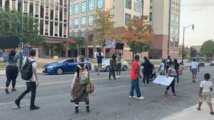 As the demonstrators marched, several other cars honked their horns as drivers raised their fists in support.