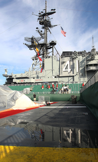 The number 41 is seen in a reelection in a puddle as preparations continue aboard the USS Midway Museum on Nov. 8, 2012, before the Battle on the Midway game between the Syracuse Orange and the San Diego State Aztecs scheduled for Sunday.