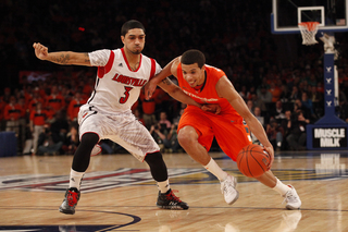 Michael Carter-Williams drives the ball into the paint past Louisville's Peyton Siva (#3)