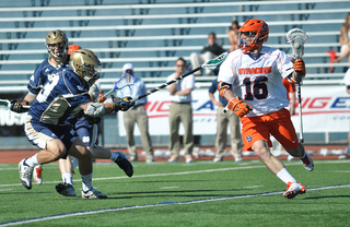 Ryan Barber runs by the outstretched stick of a UND player.