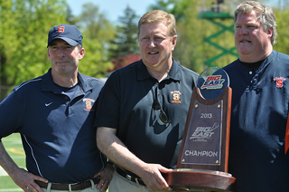 Syracuse coaches Kevin Donahue, John Desko and Roy Simmons III hold the Big East tournament championship trophy.