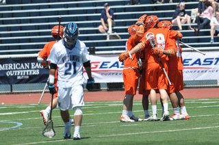 Syracuse celebrates a goal as Villanova long-stick midfielder John LoCascio walks away.