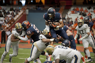 SU running back George Morris II attempts to hurdle over the Pittsburgh defense.