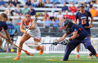 Treanor takes a swipe at a groundball just outside of UVA's   crease.