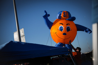 John Ostapovich, a Syracuse University graduate from the class of 1997, tries to make an inflatable Otto stay vertical atop his SUV. 