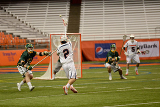 Rice raises his stick in the air as the ball flies through the Siena defense.