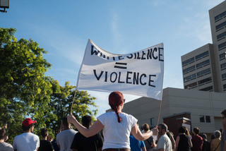 Nikeeta Slade holds a sign that says 