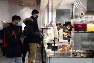 Food service employees at CoreLife Eatery prepare orders for students.